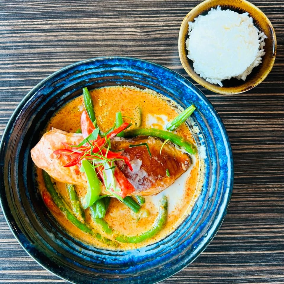 Bistro Saffron's salmon in red curry sauce with green beans, chili, and a side of rice.